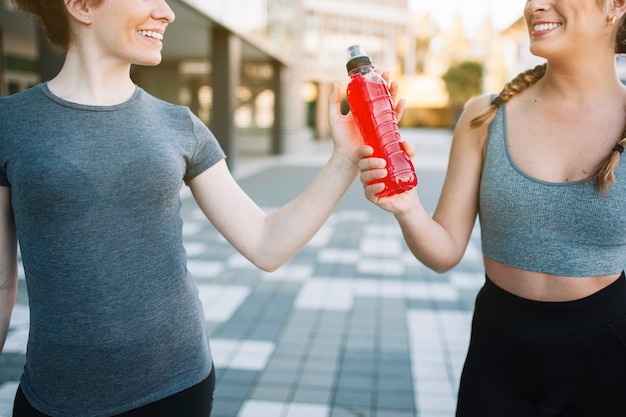 Cosecha mujeres en forma alegre con bebida roja