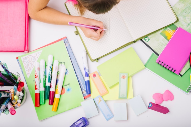 Foto gratuito cosecha de niño en la mesa con los útiles escolares