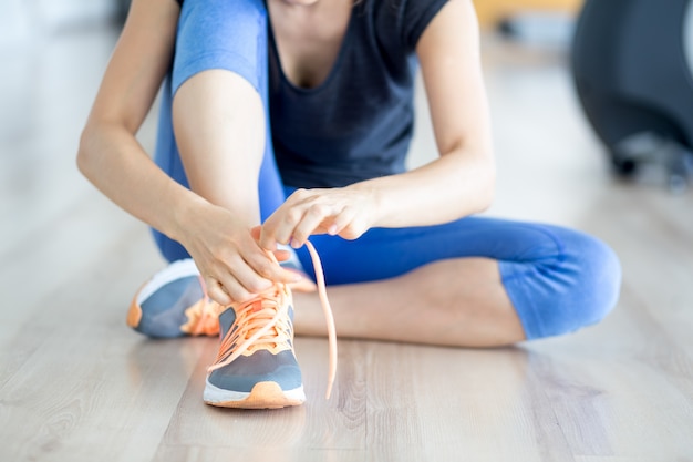 Cosechado, vista, mujer, atar, cordón, gimnasio, piso