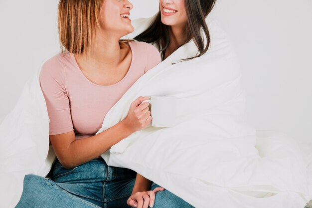 Coseche la pareja femenina feliz en manta