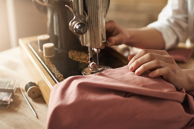 Coser mantiene mi mente relajada. Captura recortada de sastre femenina trabajando en un nuevo proyecto, haciendo ropa con máquina de coser en el taller, estando ocupada. Joven diseñadora que hace realidad sus ideas