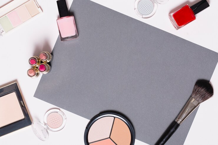 Foto gratuito cosméticos decorativos alrededor de la hoja de papel gris