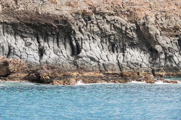 Costa acantilada de tiro largo con agua cristalina.