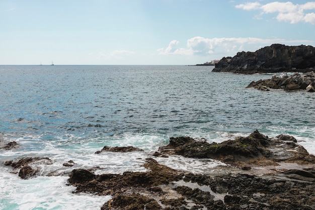 Costa acantilada de tiro largo con agua cristalina.