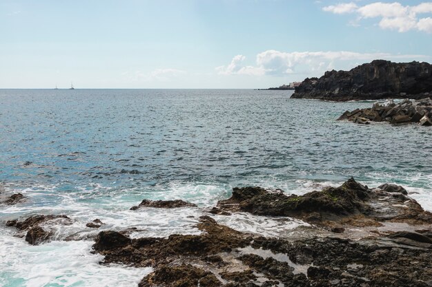 Costa acantilada de tiro largo con agua cristalina.