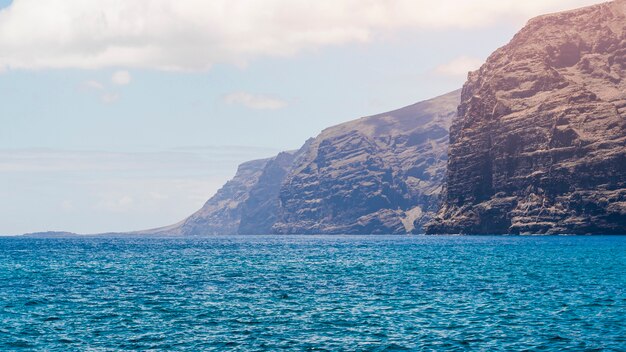 Costa acantilada de tiro largo con agua cristalina.