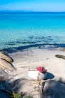 Foto gratuita costa del mar egeo con barco varado, rocas en la playa, agua azul, grecia