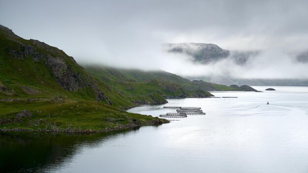 Costa nublada con granjas de salmón en el norte de Noruega cerca de Nordkap