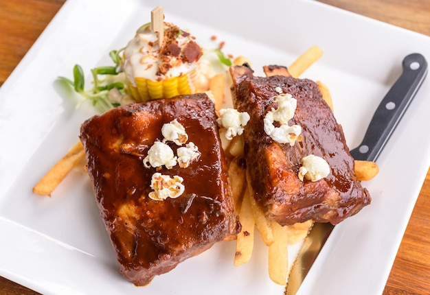 Costillas de cerdo a la barbacoa en plato fotografía de comida