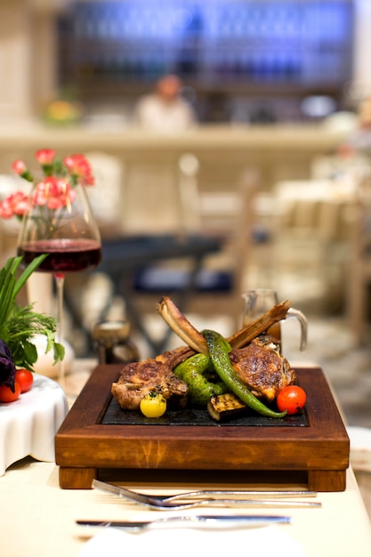 Costillas de cordero kebab y verduras a la parrilla servidas en tablero cuadrado