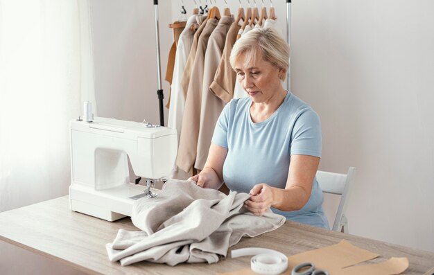 Costurera femenina en el estudio con máquina de coser