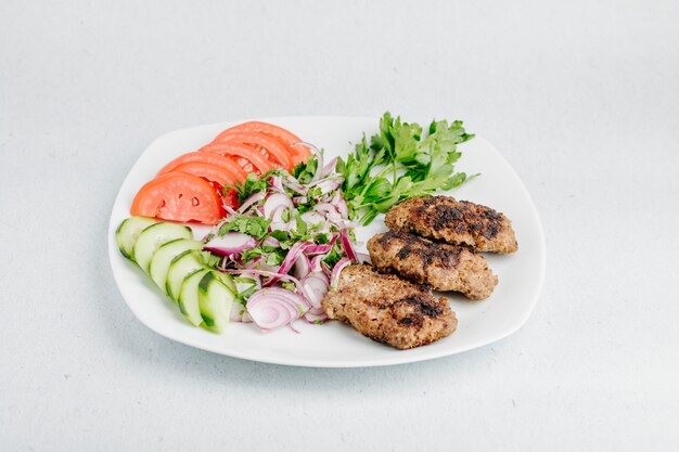 Cotlet de pollo con verduras y ensalada verde.