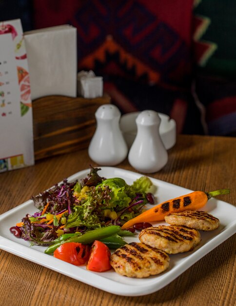 Cotlets de pollo con zanahoria a la parrilla y ensalada verde.