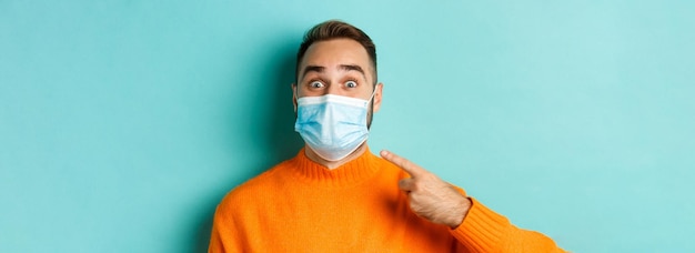 Foto gratuita covid concepto de distanciamiento social y cuarentena primer plano de un hombre alegre señalando con el dedo a su médico