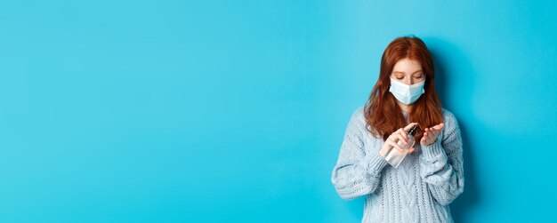 Covid de invierno y concepto de distanciamiento social pelirroja estudiante con mascarilla limpia las manos con sani