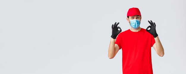 Covid selfquarantine compras en línea y concepto de envío guapo repartidor con gorra roja camiseta ...