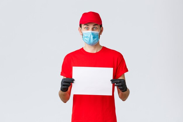 Covid selfquarantine concepto de compras y envío en línea emocionado mensajero con guantes de uniforme rojo y ...