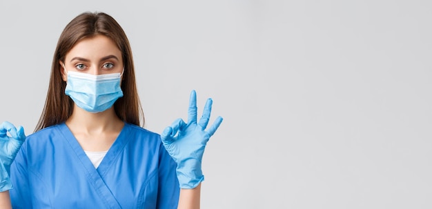 Covid19 prevención de virus salud trabajadores de la salud y concepto de cuarentena Enfermera o doctora profesional en la clínica exfoliantes azules y máscara médica muestran el signo correcto todo bajo control