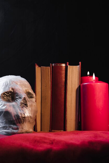 Cráneo en una bolsa de plástico con libros y velas