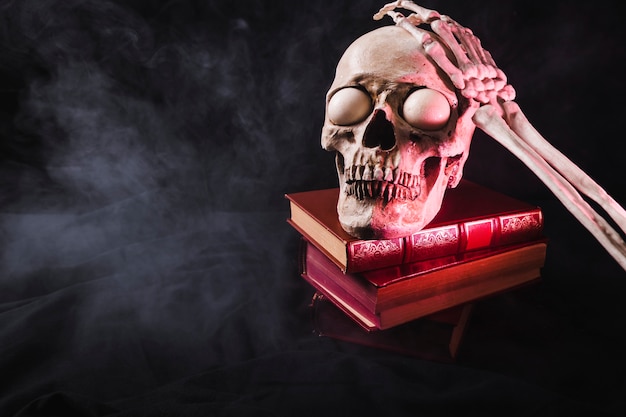 Foto gratuita cráneo con ojos espeluznantes y brazo esqueleto en la parte superior