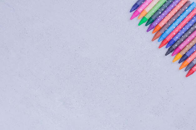 Foto gratuita crayones de colores aislados en superficie gris