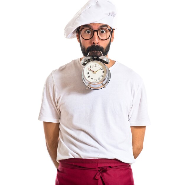 Crazy chef sosteniendo un reloj sobre fondo blanco