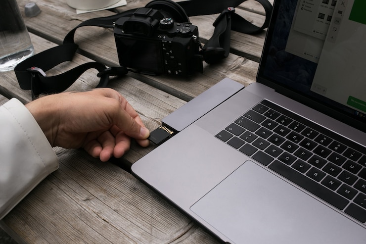 Foto gratuito creador de contenido independiente utiliza adaptador de tarjeta de memoria