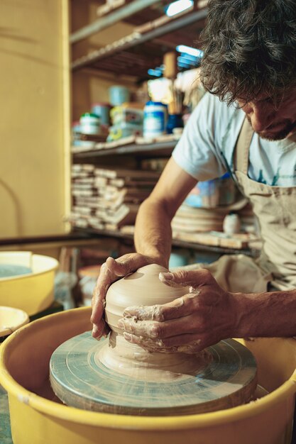 Creando un frasco o jarrón de arcilla blanca de cerca. Maestro cántaro.