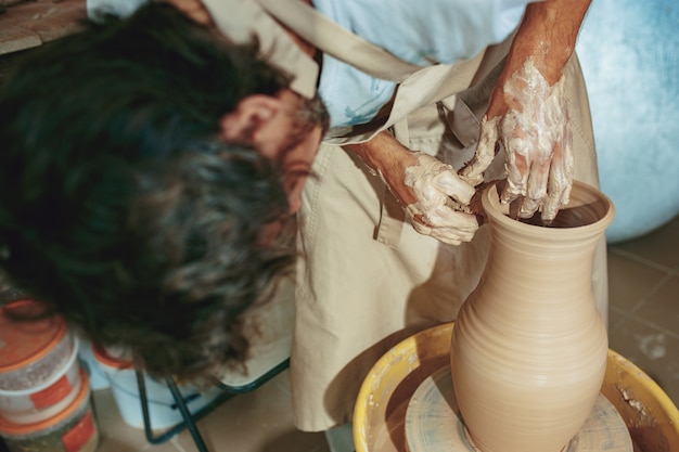 Creando un frasco o jarrón de arcilla blanca de cerca. maestro cántaro.