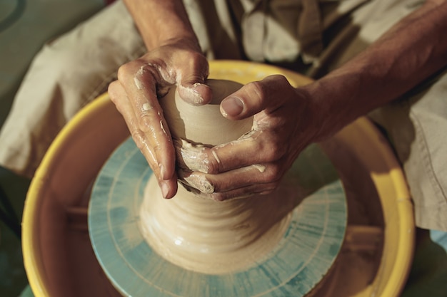 Creando un frasco o jarrón de arcilla blanca de cerca. Maestro cántaro.