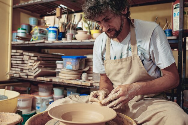 Creando un frasco o jarrón de arcilla blanca de cerca. Maestro cántaro.