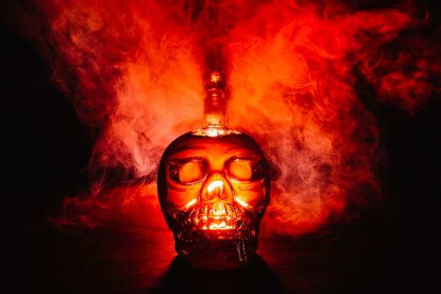 Creativa botella en forma de cráneo en el humo