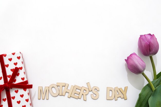 Creativo lettering del día de la madre con caja de regalos y dos rosas
