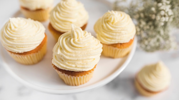 Crema batida en magdalenas sobre soporte de la torta