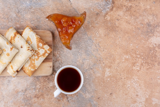 Foto gratuita crepes con confitura de higos y una taza de té