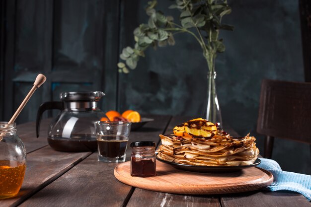 Crepes franceses caseros frescos hechos con huevos, leche y harina, rellenos de mermelada en un plato vintage