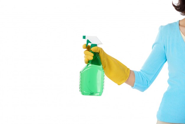 Criada recortada de pie con la mano estirada sosteniendo la botella de spray de detergente