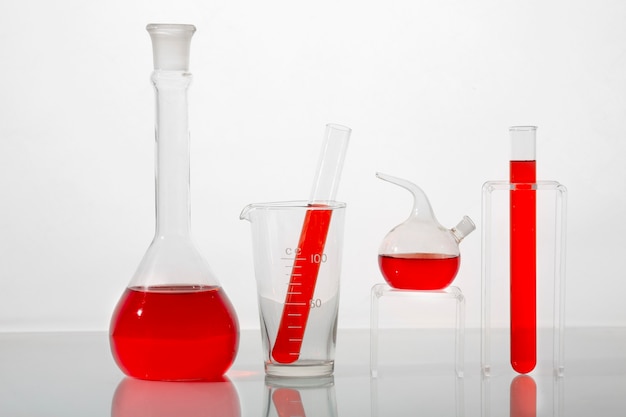 Cristalería de laboratorio con surtido de líquido rojo.