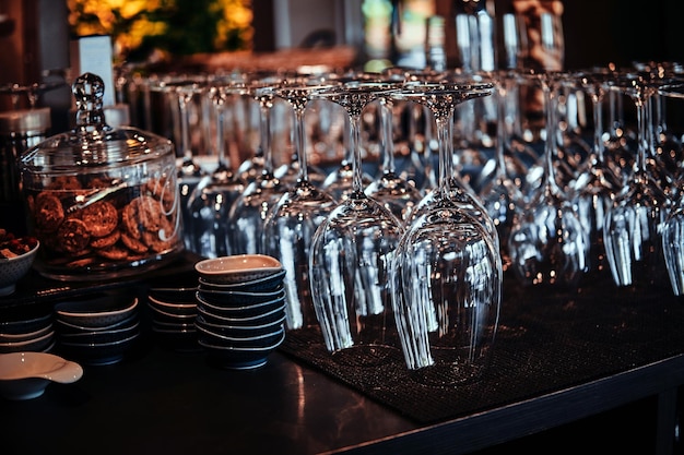 La cristalería de vino cristalina en la mesa de los camareros está esperando a los clientes.