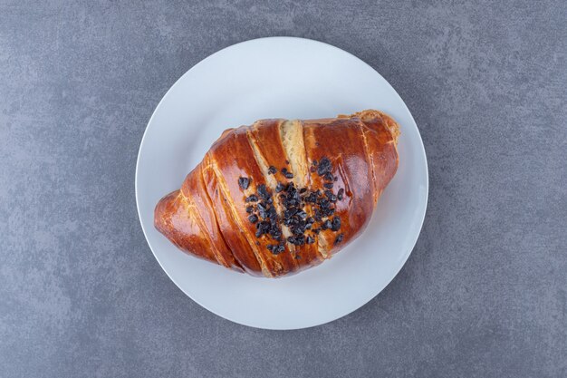 Croissant casero con chocolate en un plato