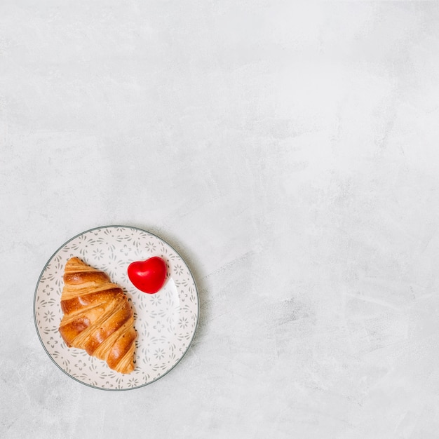 Croissant cerca del corazón del ornamento en la placa