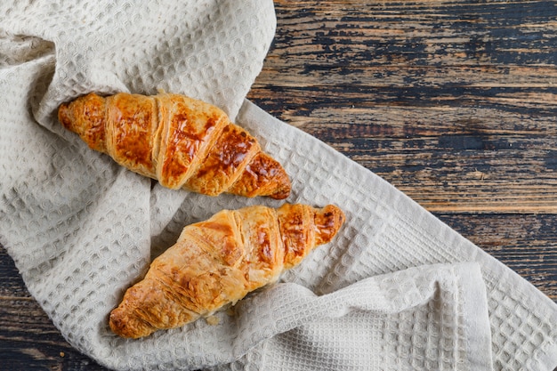 Croissant en madera y papel de cocina. aplanada