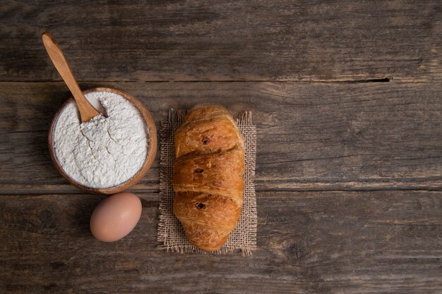 Croissant recién horneado con huevo de gallina y harina. Foto de alta calidad