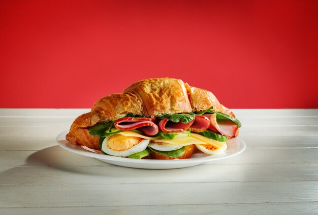 croissant relleno de tocino, huevos y lechuga