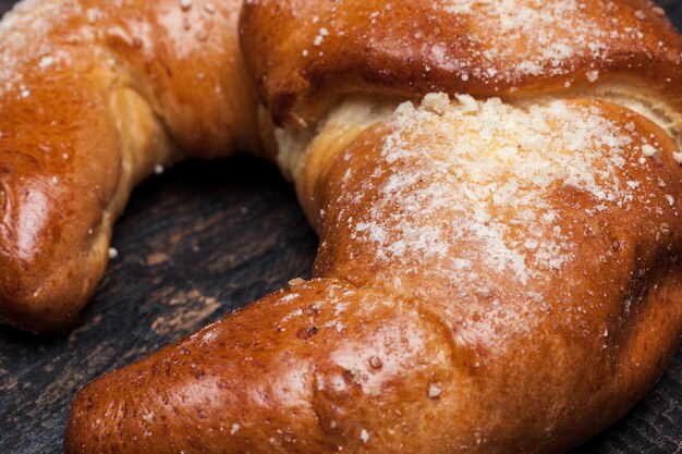 Croissant sabroso sobre fondo de madera