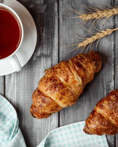 croissant con taza de té en la mesa