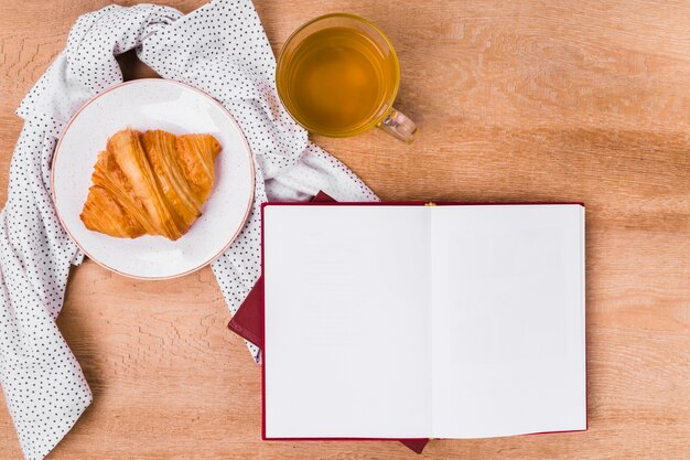 Croissant de vista superior con libro en blanco