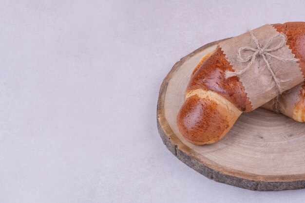 Croissants aislado en una bandeja de madera sobre superficie gris