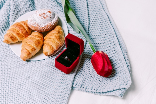 Foto gratuita croissants con anillo de boda en bufanda