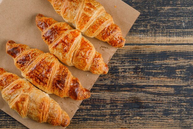 Croissants en bolsa de madera y papel. aplanada